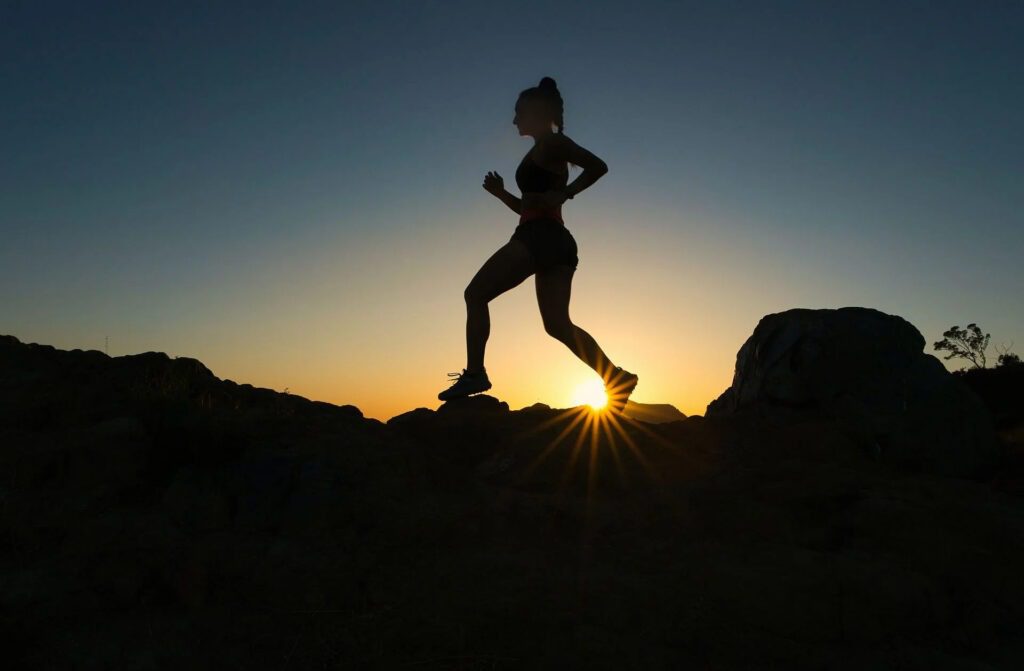 Woman running at sunrise